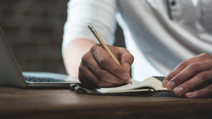 Person bringt ihre Gedanken achtsam und in Ruhe zu Papier